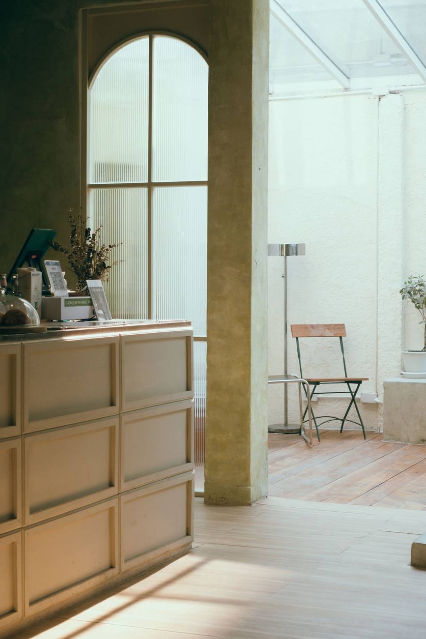 Demonstration photograph. A bright, spare interior with an arched window and a wooden counter.