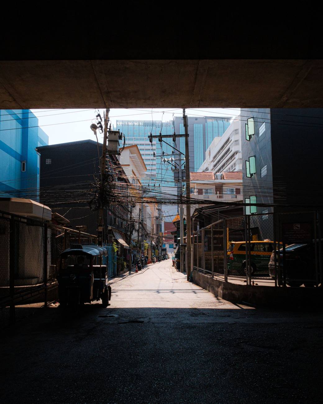 Demonstration photograph. A dark passage opening onto a bright, narrow lane between buildings.