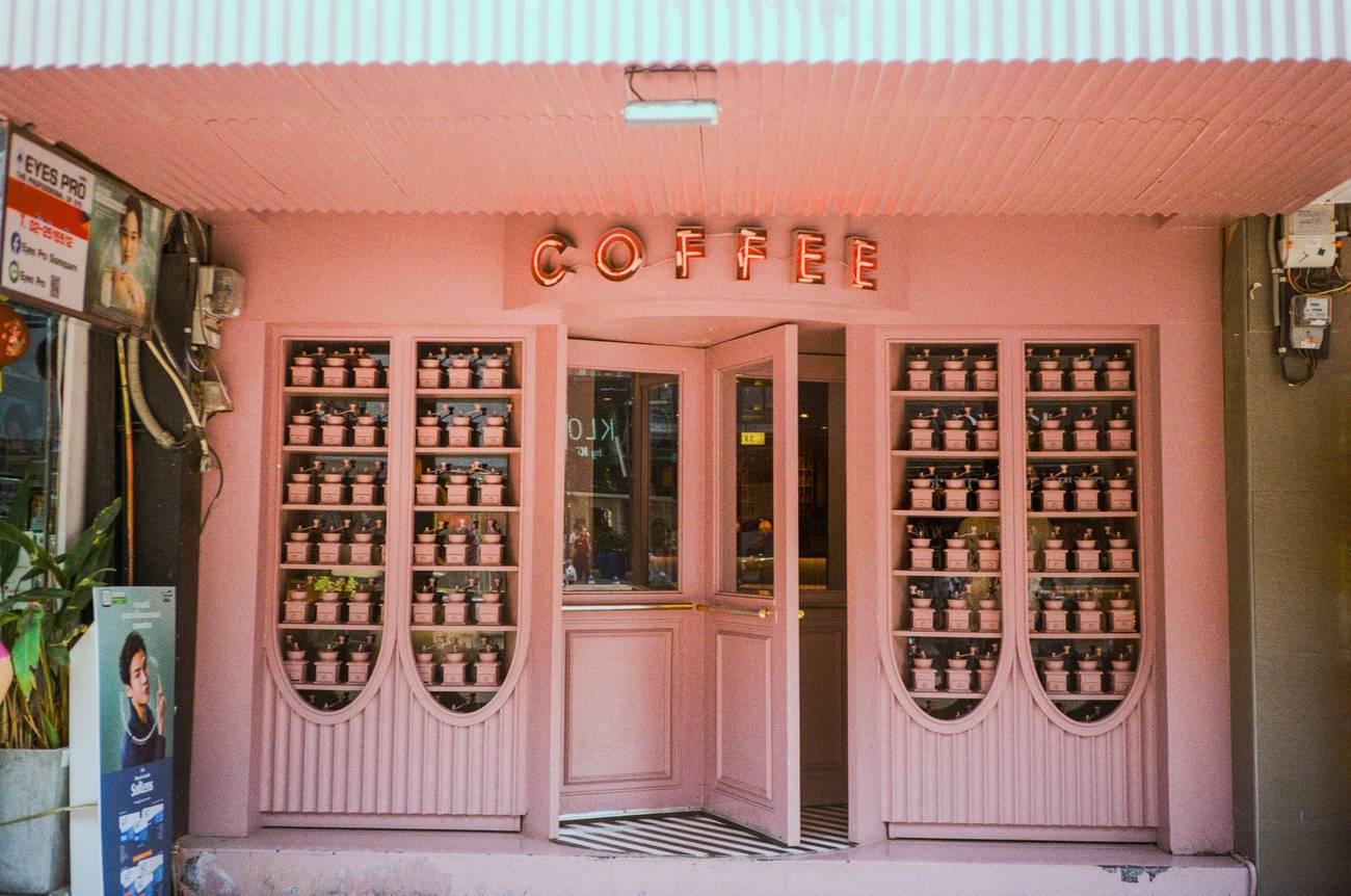 Demonstration photograph. A pink-painted coffee shop front with arched glass doors.