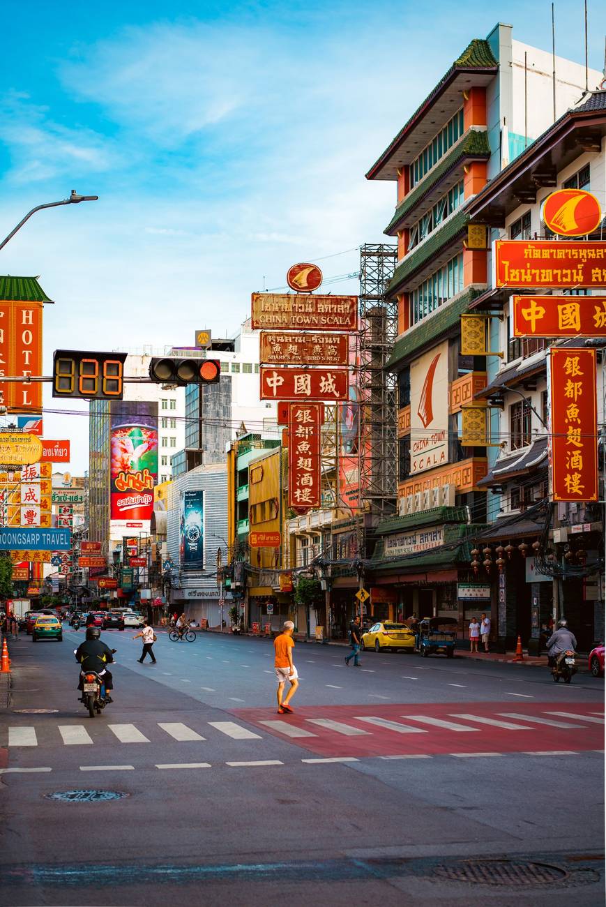 Demonstration photograph. A Chinatown street by day under a blue sky, hung with vertical signs.