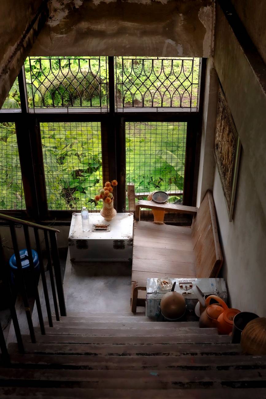 Demonstration photograph. A dark wooden interior with a bench beneath a window of small glass panes.